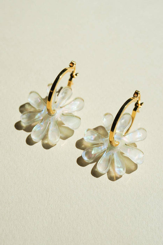 Floral earrings with gold accents on a beige background