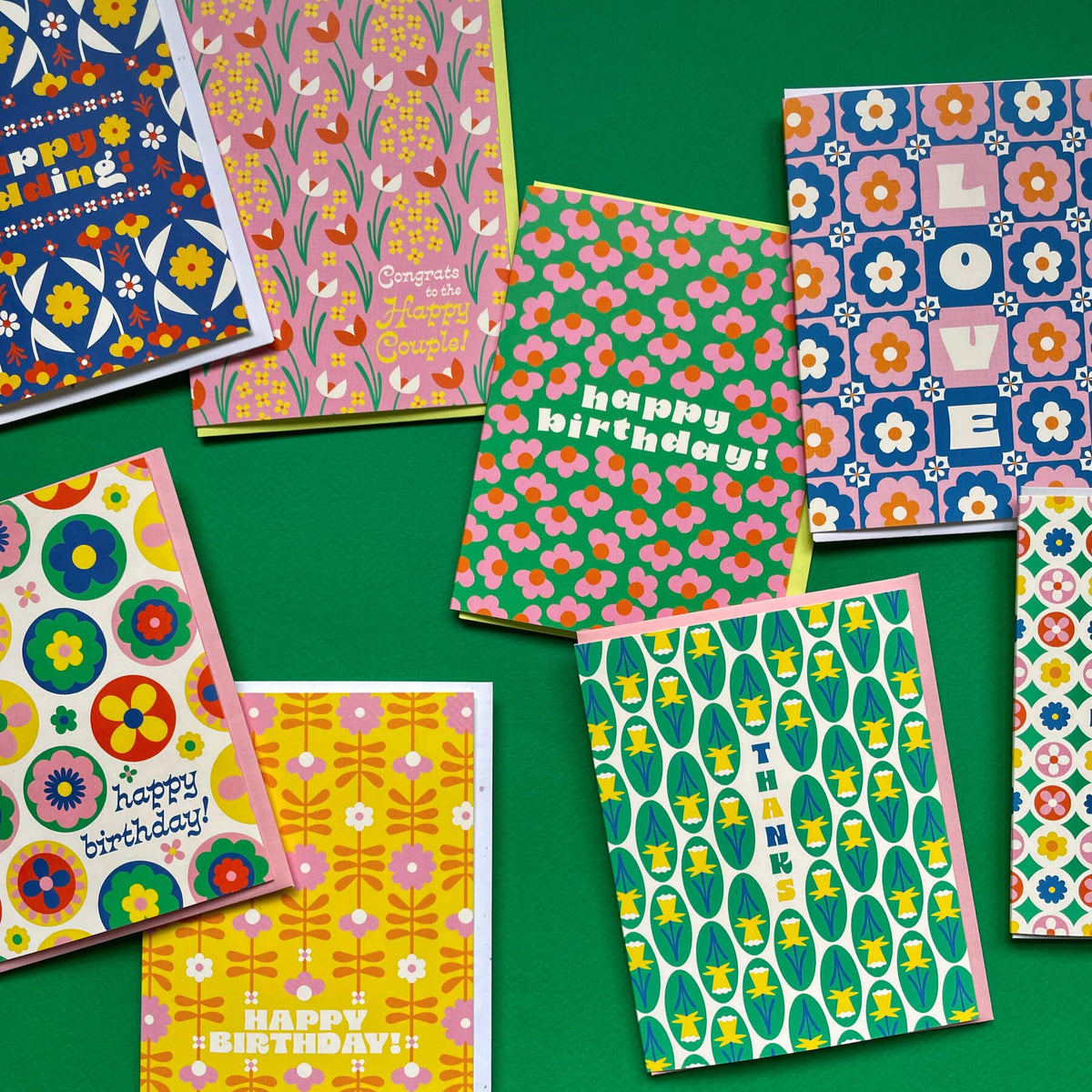 Collection of colorful patterned greeting cards on a green background