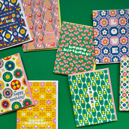 Collection of colorful patterned greeting cards on a green background