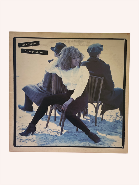 Album cover with a person sitting on a chair, surrounded by other people, with text at the top. Foreign Affair Vinyl Record - Tina Turner