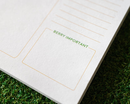Notebook with 'BERRY IMPORTANT' text on a grass background