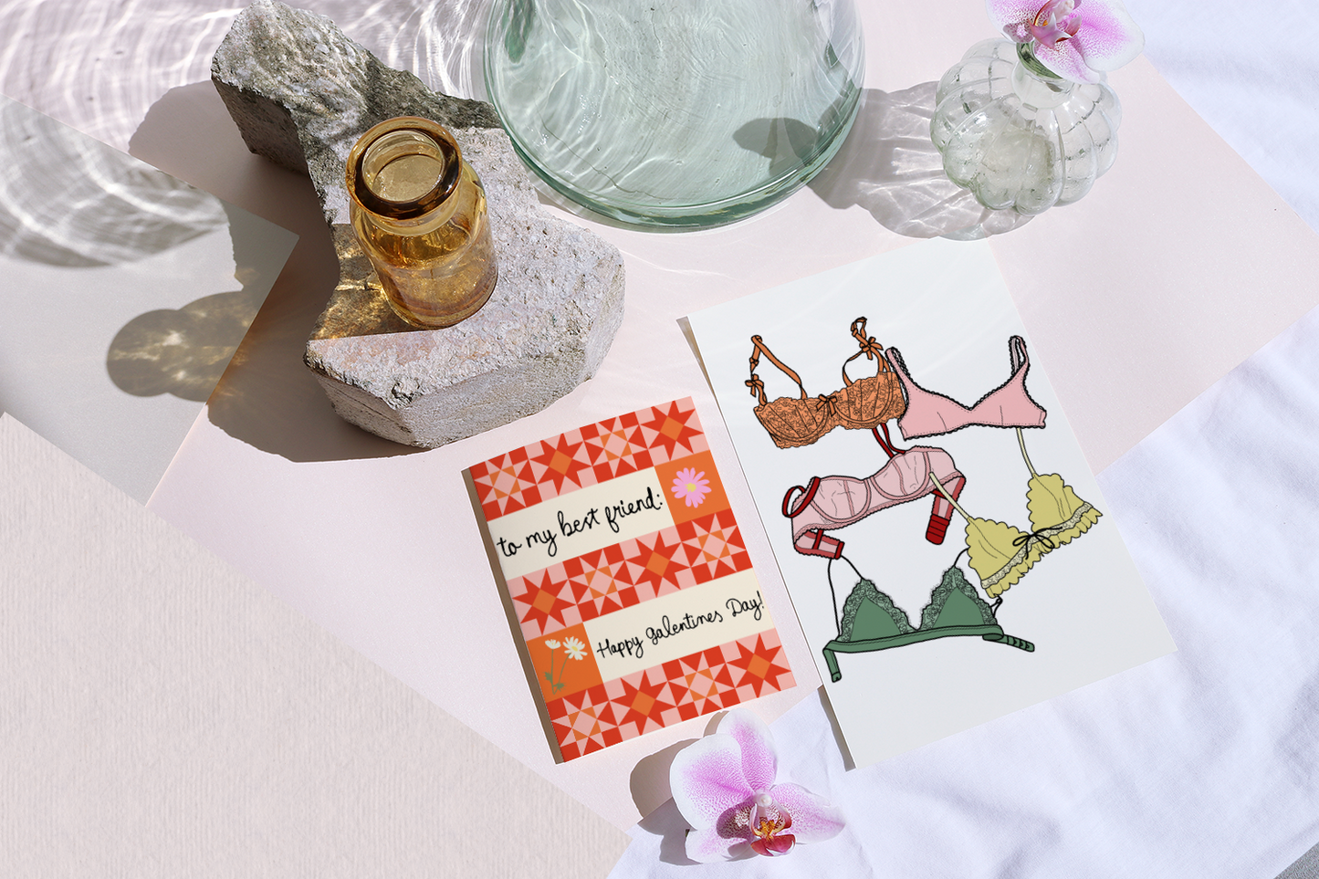 Valentine's Day card with lingerie illustrations on a table with a card and orchid.