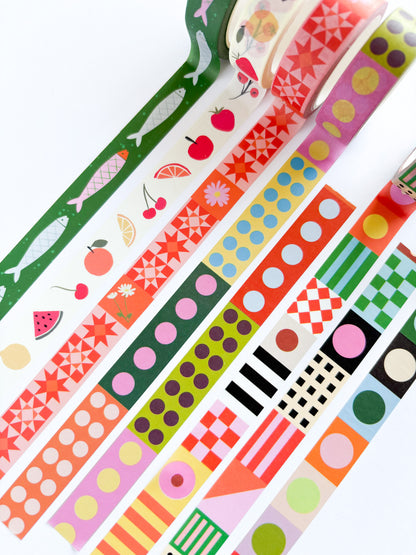 A set of colorful patterned washi tapes arranged diagonally on a white background, featuring various designs including fruit prints, geometric shapes, stripes, and polka dots.