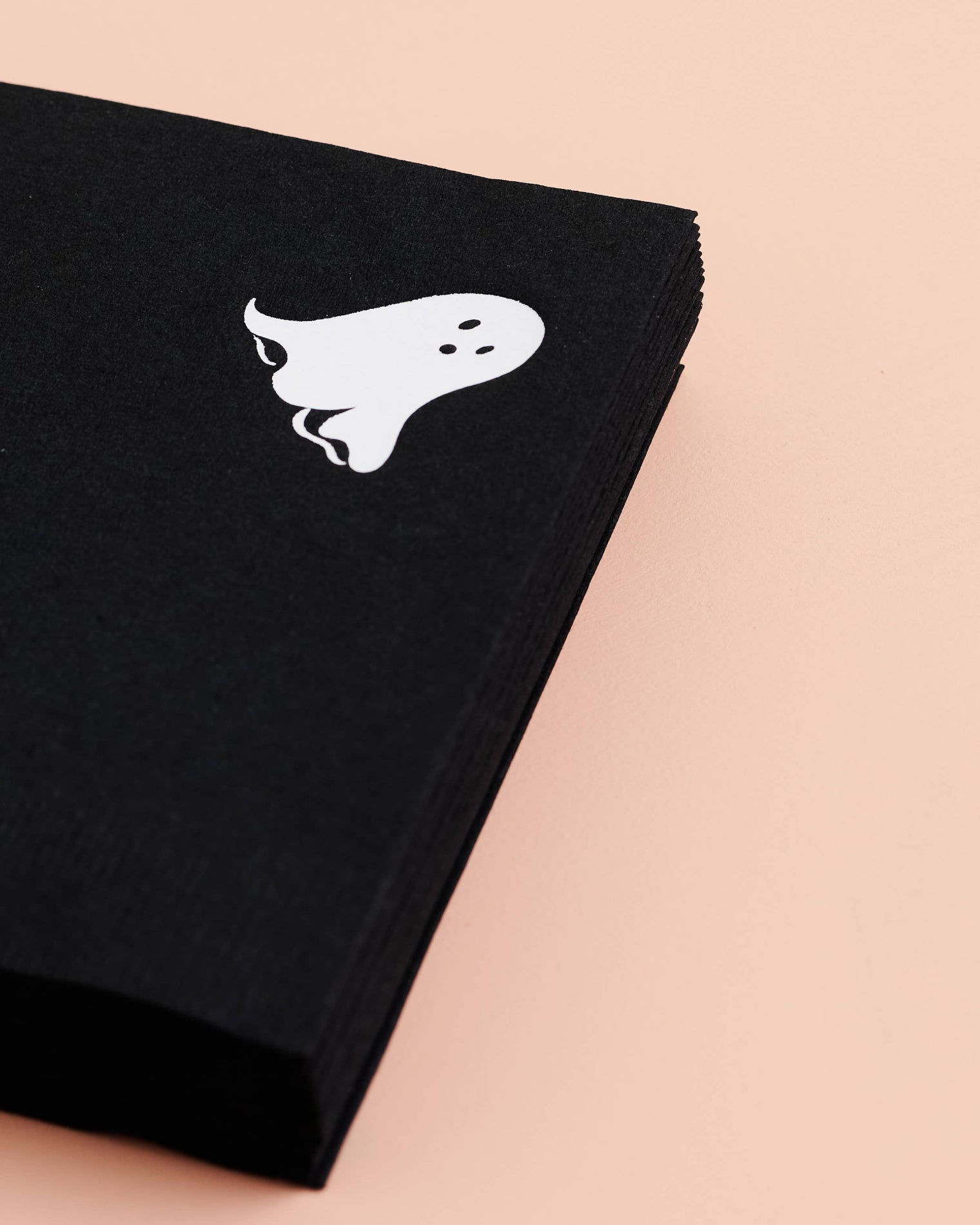Black napkins with a white ghost design on a beige background