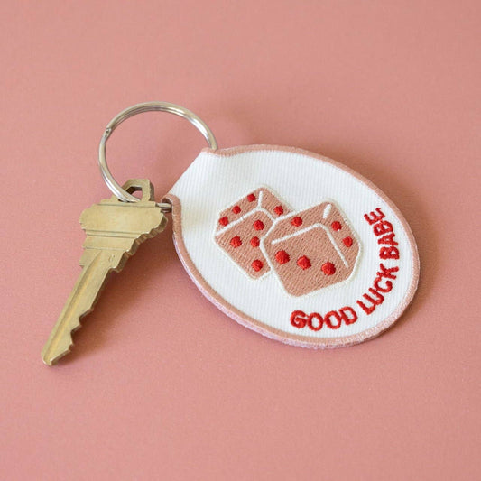 Keychain with 'Good Luck Babe' text and cookie design on a pink background