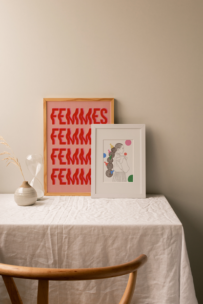 Two framed artworks on a table with a neutral background