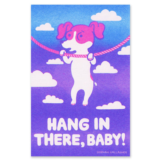 A risograph art print featuring a stylized white dog with pink ears and paws hanging from a pink rope against a blue-to-purple sky with white clouds. The text at the bottom reads “HANG IN THERE, BABY!” with the artist name “Sionan Gallagher” below.