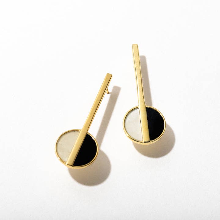 Pair of gold and black earrings on a white background