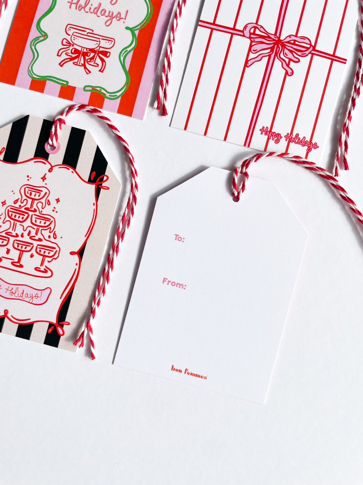 Holidays-themed gift tags and cards with red and white designs on a white background.