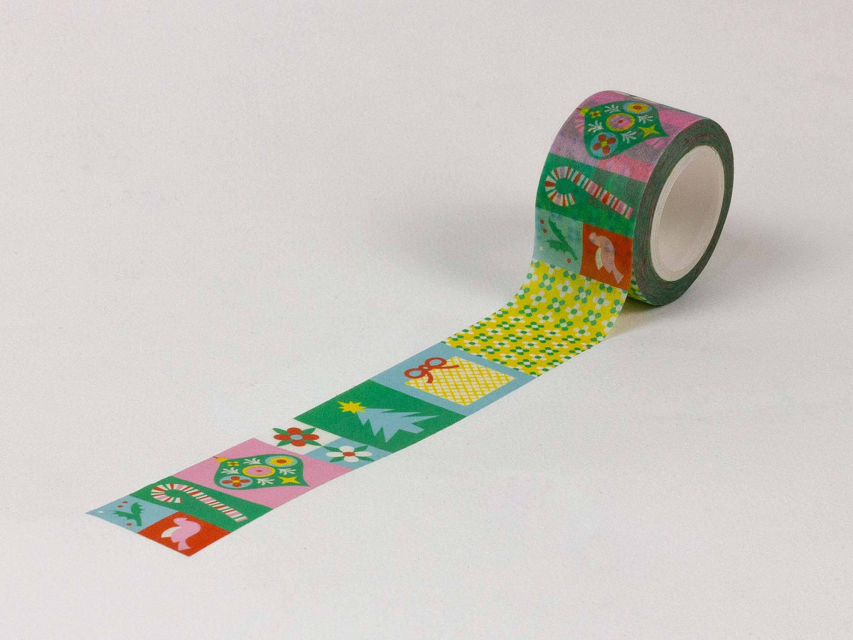 A roll of decorative washi tape with a colorful retro pattern, partially unrolled to show its design on a light gray background.