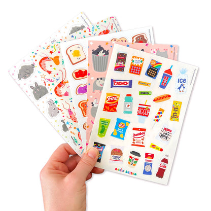 Hand holding a sheet of colorful stickers with various designs on a white background