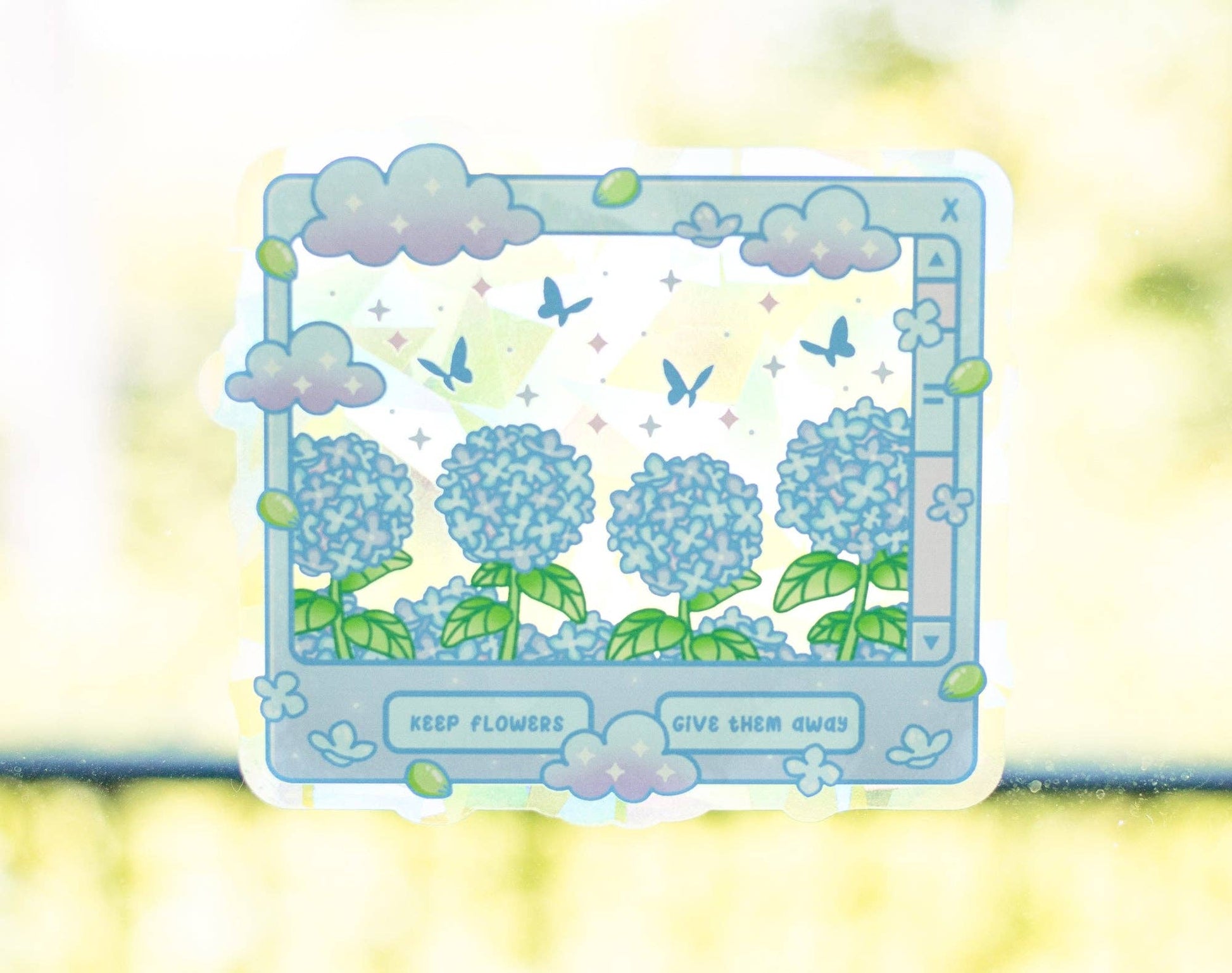 A die-cut sticker featuring a pastel illustration of blue hydrangea flowers, green leaves, butterflies, and clouds inside a retro computer-monitor frame, with the text 'KEEP FLOWERS GIVE THEM GROW' at the bottom, shown against a soft-focus yellow-green background.