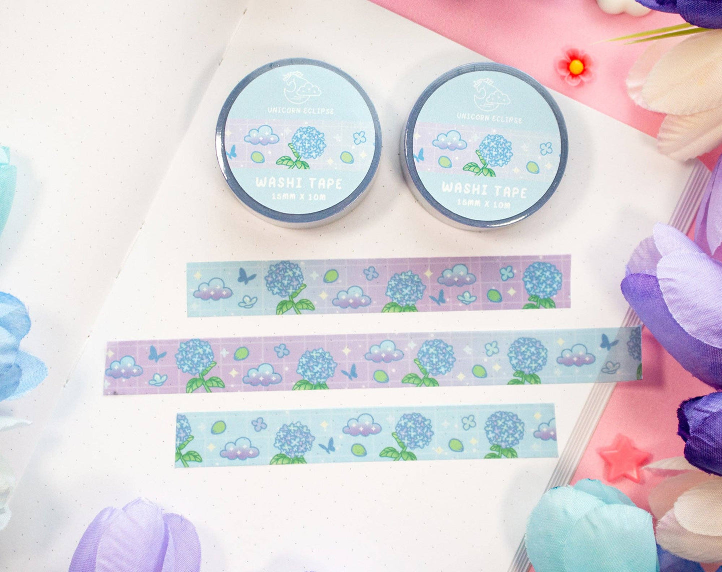 Two rolls of washi tape with decorative strips of hydrangea washi tape on a colorful background.