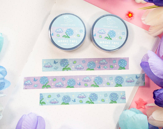 Two rolls of washi tape with decorative strips of hydrangea washi tape on a colorful background.