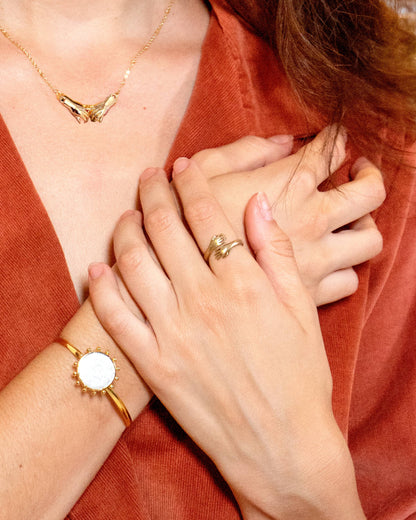 Close-up of hands wearing gold jewelry on a red fabric background, I Wanna Hold Your Small Hand Ring