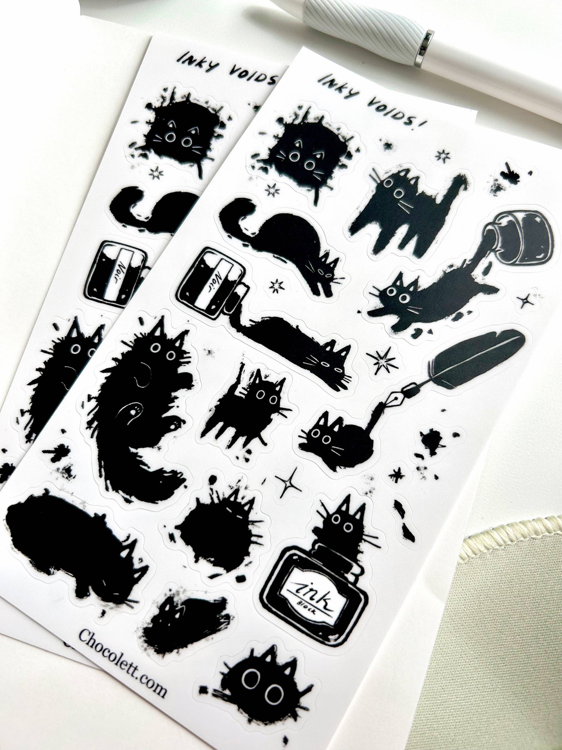 Sheet of black cat-themed stickers with 'Inky Voids' text on a white background.
