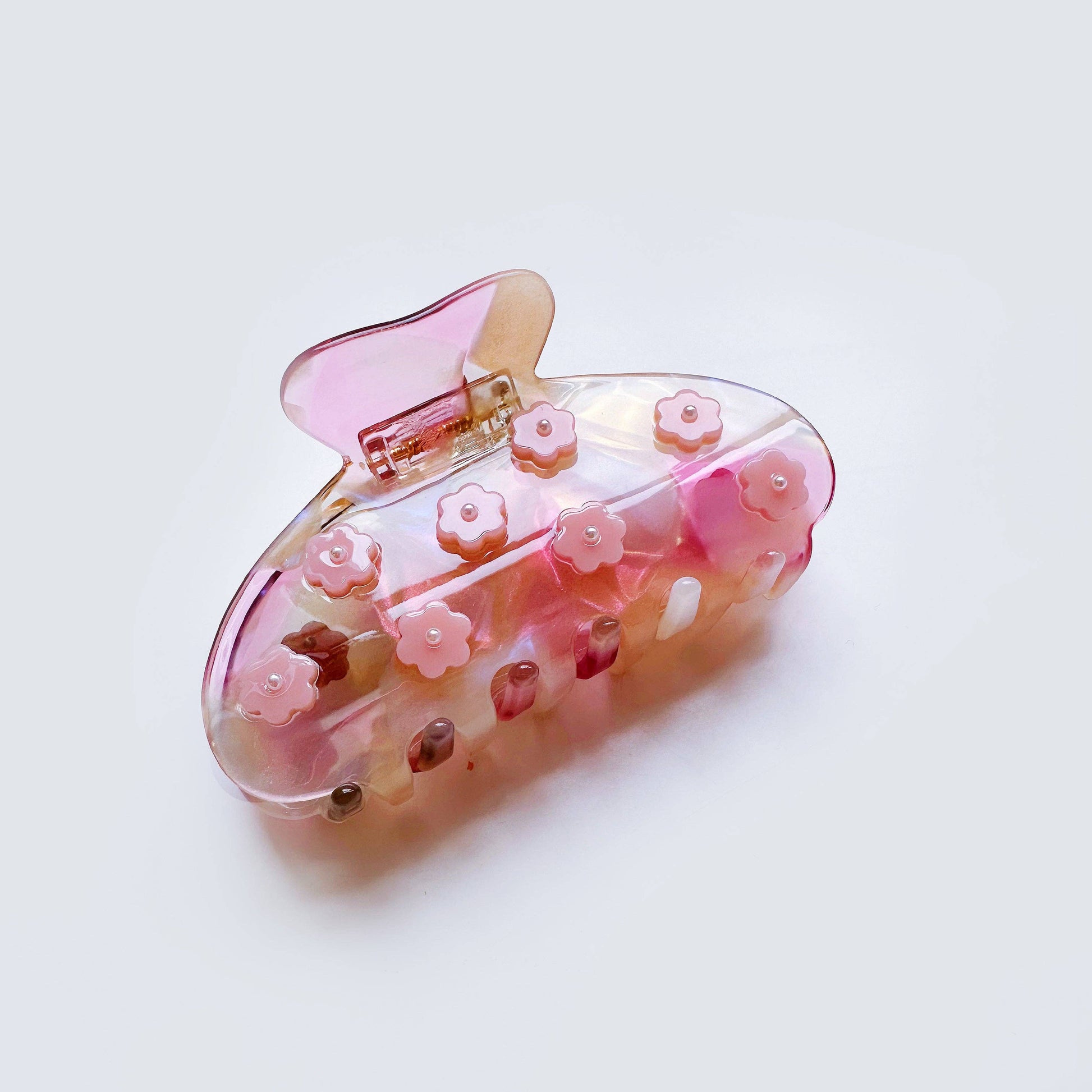 Pink hair clip with floral designs on a white background