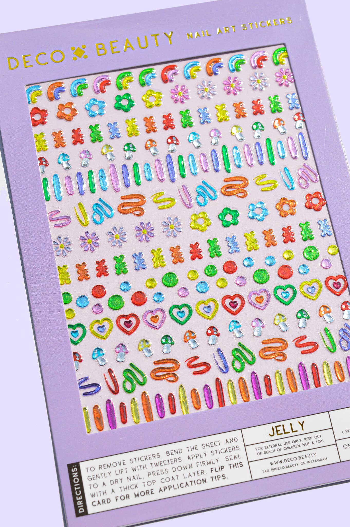 A sheet of colorful nail art stickers from Deco Beauty, featuring various floral, heart, and barrette designs in bright pastel and neon colors, shown on a lavender background.