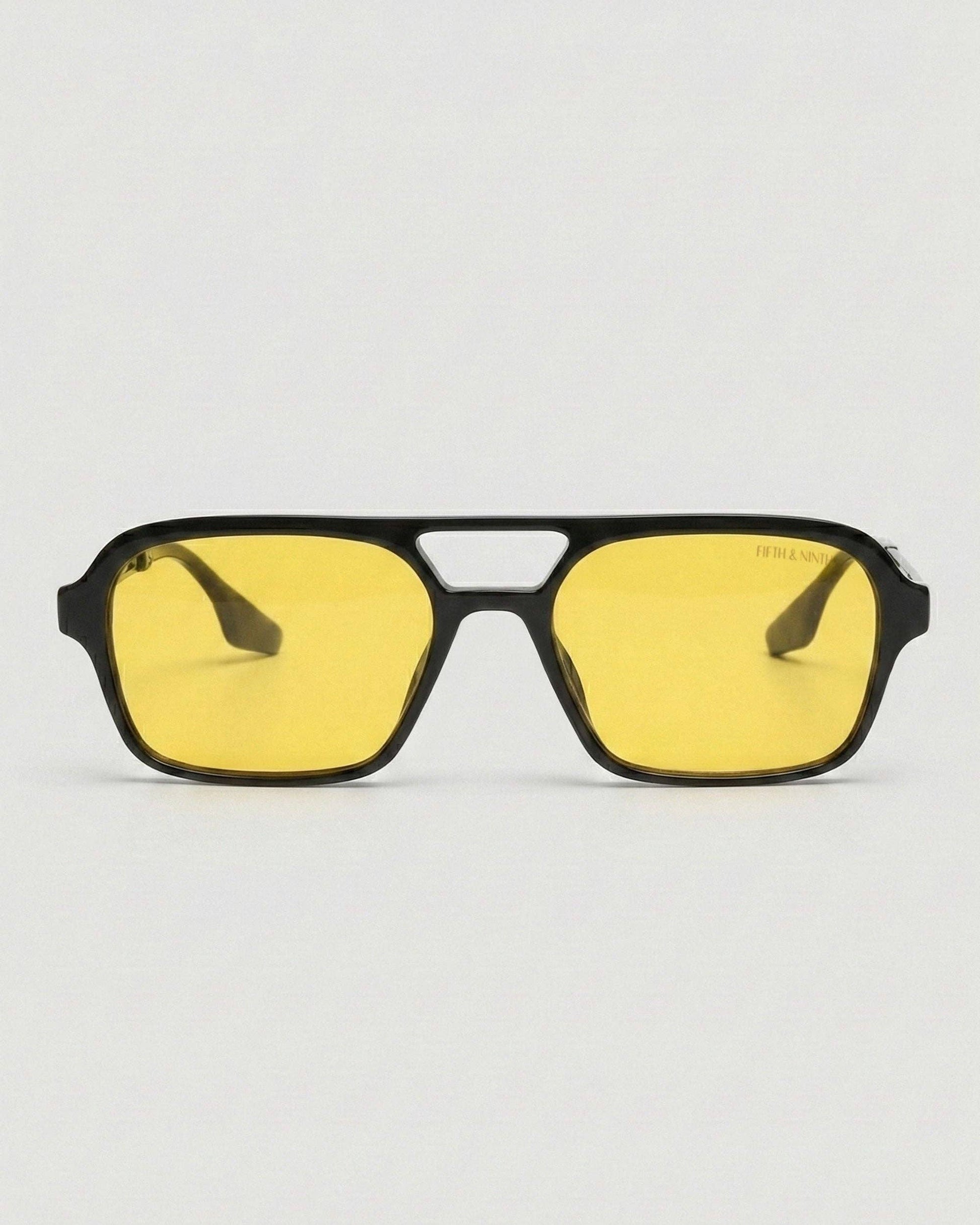 Sunglasses with yellow lenses and black frame on a white background