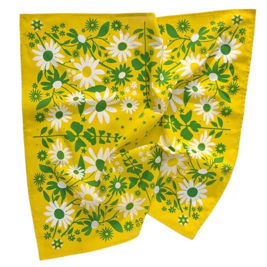 Floral patterned fabric with white flowers and green leaves on a yellow background
