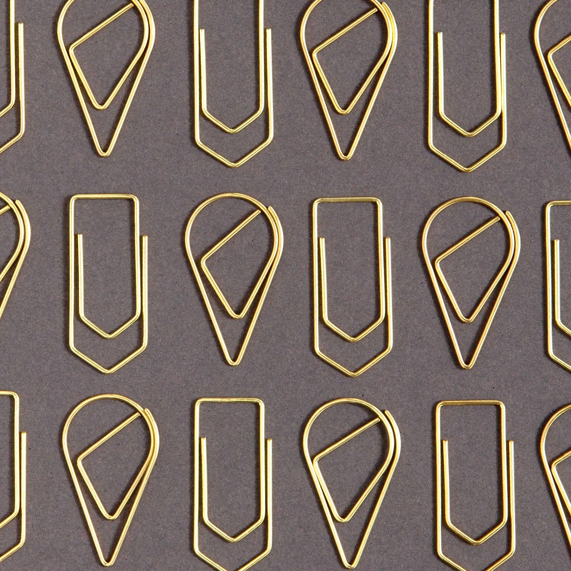 Pattern of gold paper clips on a gray background
