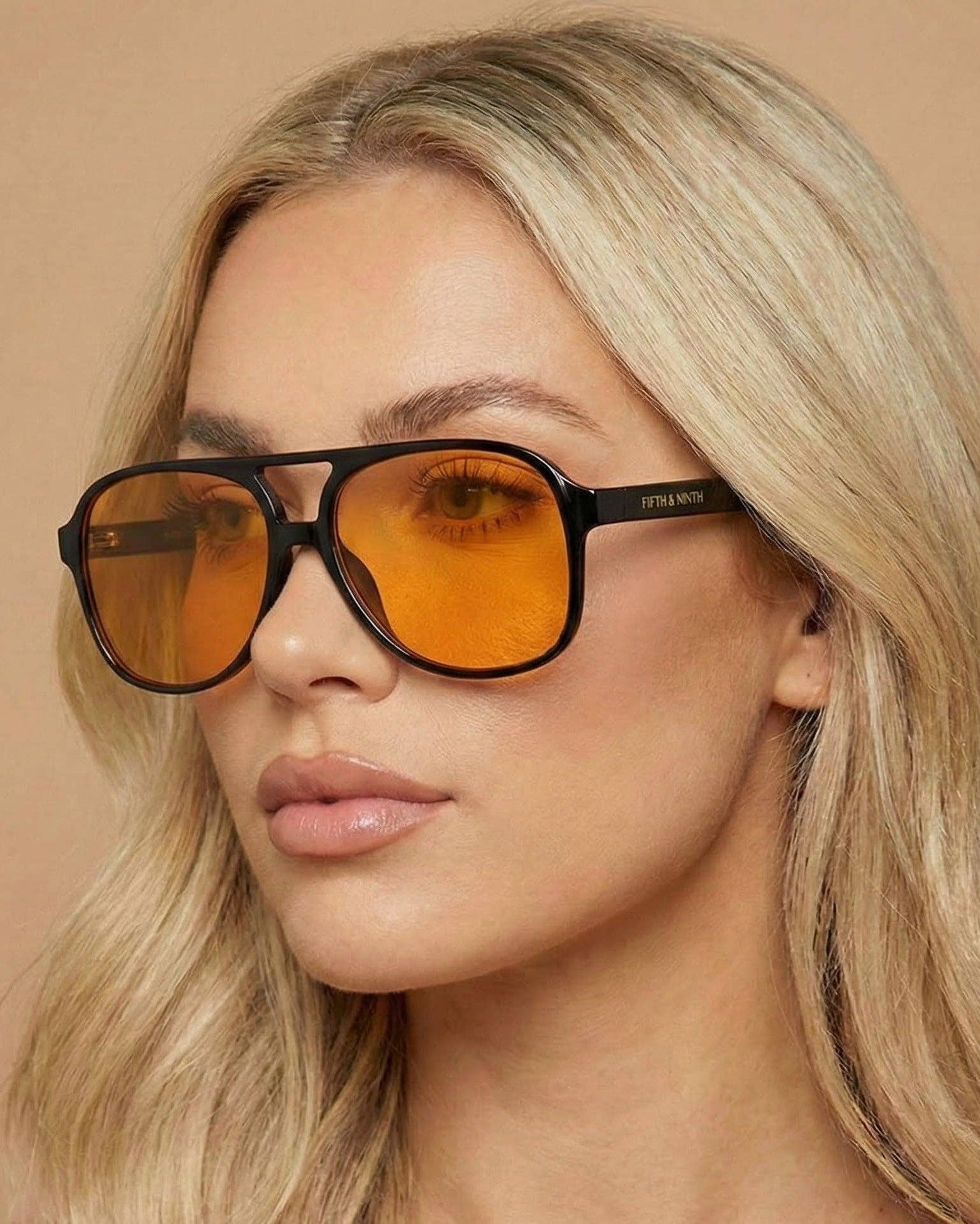Woman wearing sunglasses with a neutral background