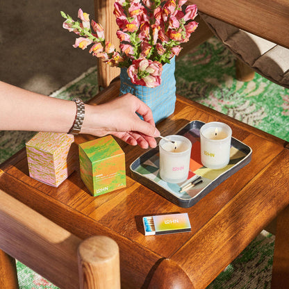 Hand reaching for a candle on a wooden table with decorative items