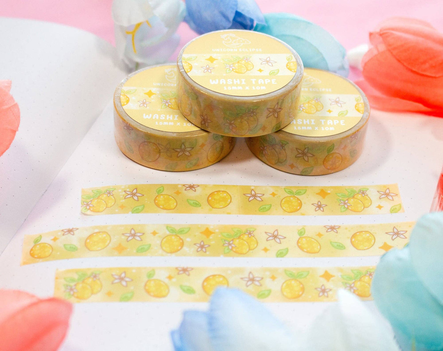 Round yellow containers with decorative tape featuring lemon designs on a colorful background.