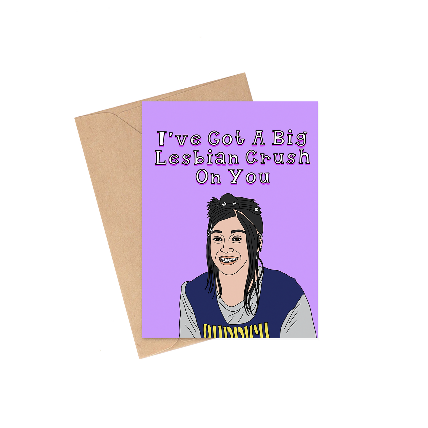 A square greeting card with a lavender front featuring the text 'I've Got A Big Lesbian Crush On You' above a cartoon illustration of a smiling person, shown with a brown kraft envelope on a white background.