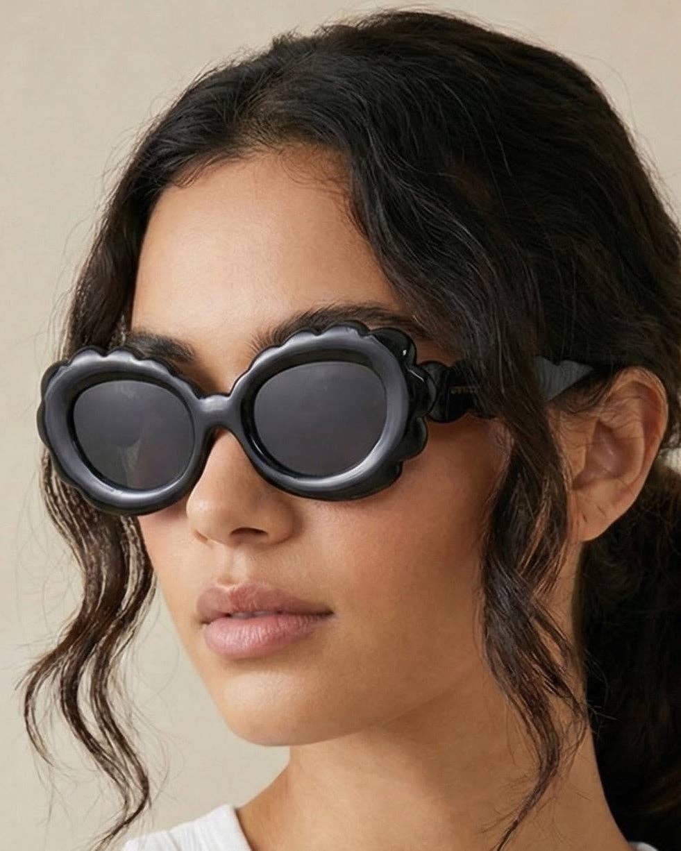 Person wearing heart-shaped sunglasses with a neutral background