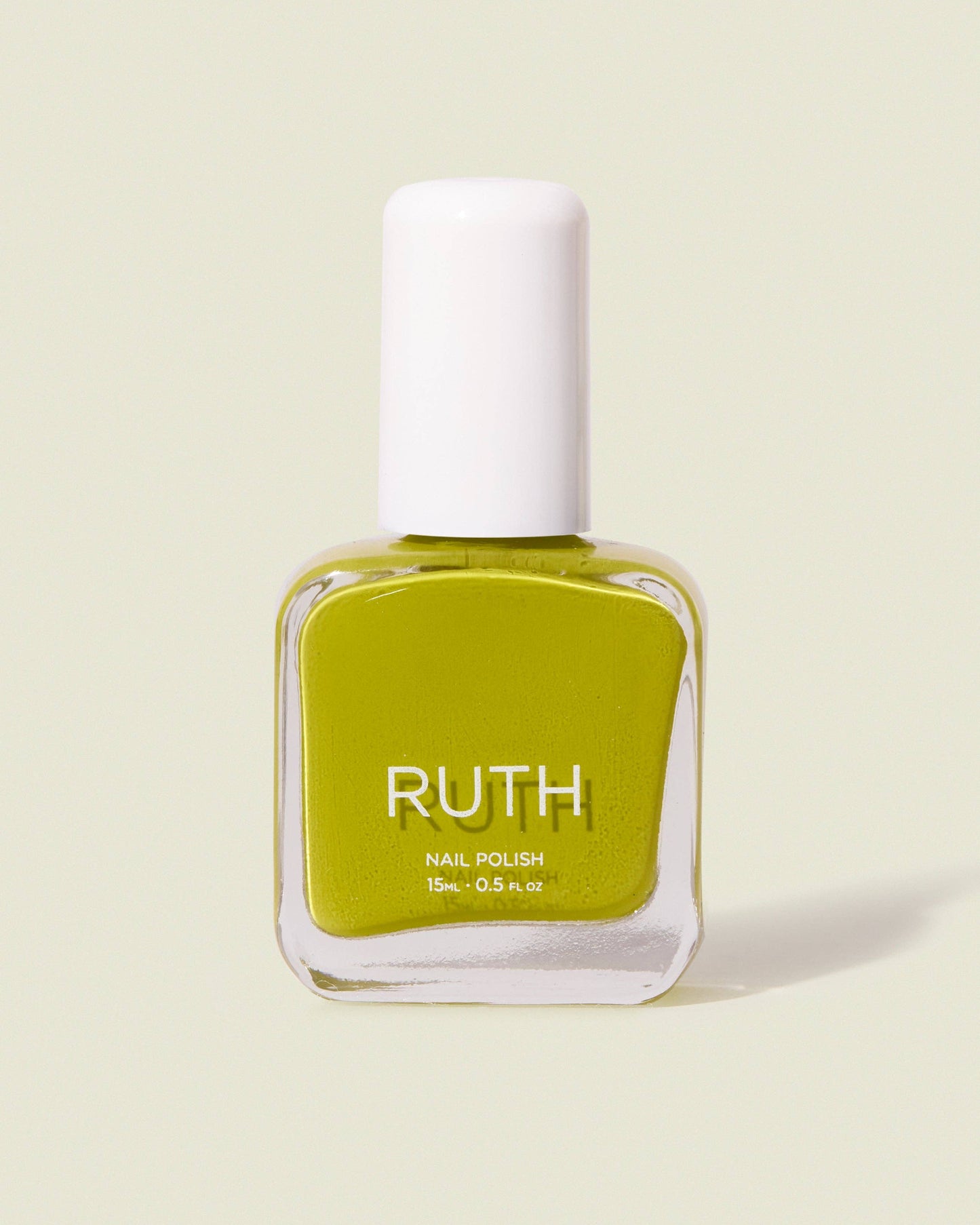 Green nail polish bottle with white cap on a light beige background, Lily Chartreuse Nail Polish Ruth Polish