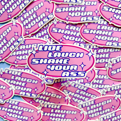 Pink stickers with 'Live Laugh Shake Your Ass' text on a pink and purple patterned background.