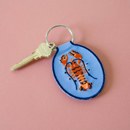 Keychain with lobster design on a pink background