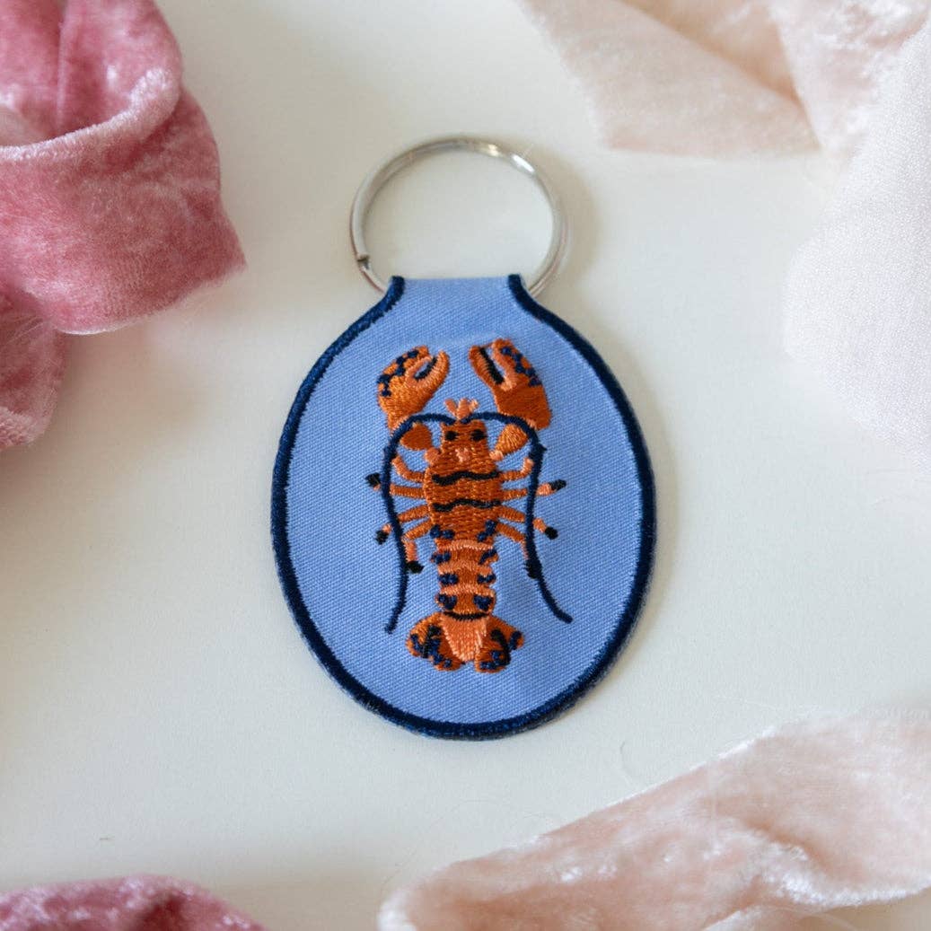 Keychain with lobster design on a blue background