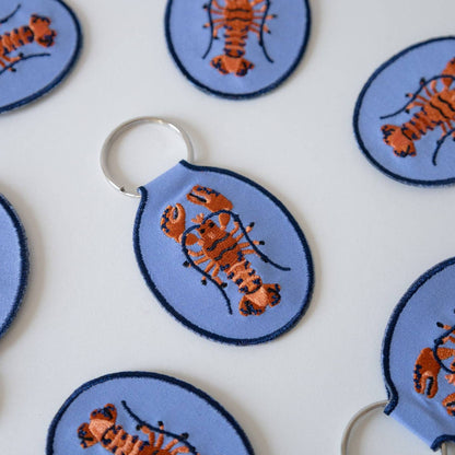 Keychains with lobster design on a blue background