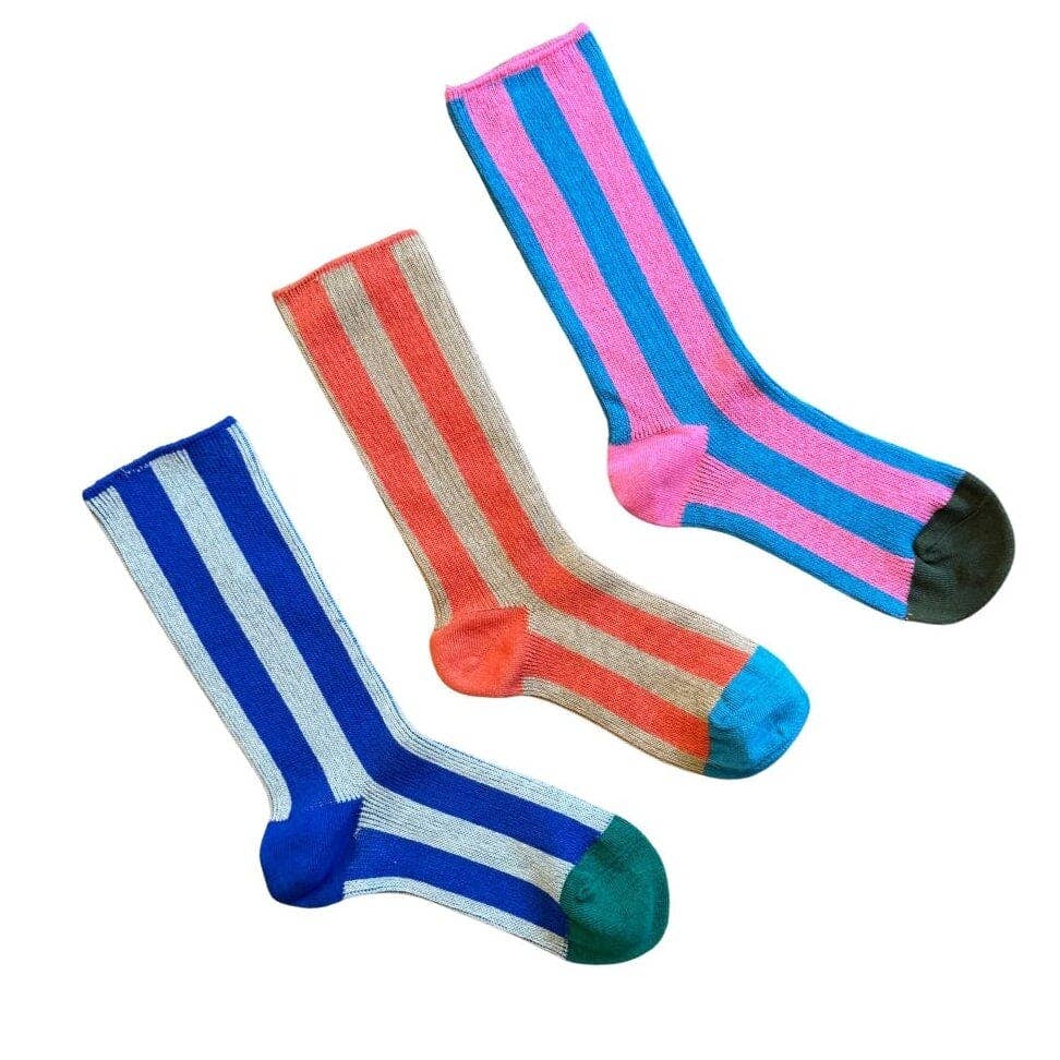 Three pairs of striped crew socks on a plain white background. One pair is blue and white, one is orange and beige, and one is pink and blue, each with a contrasting colored toe and heel.
