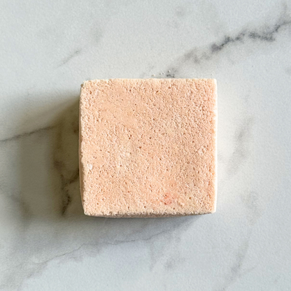 Square pink bar of soap on a marble surface