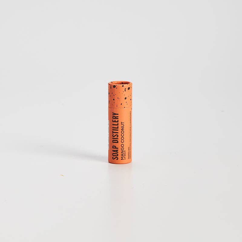 Cylindrical container with cork-like texture and 'SOAP DISTILLERY' branding on a white background. Mango Coconut Lip Balm