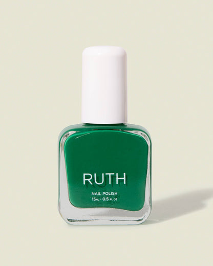 Green nail polish bottle with white cap on a beige background,  Maryjane Medium Green Nail Polish Ruth POlish