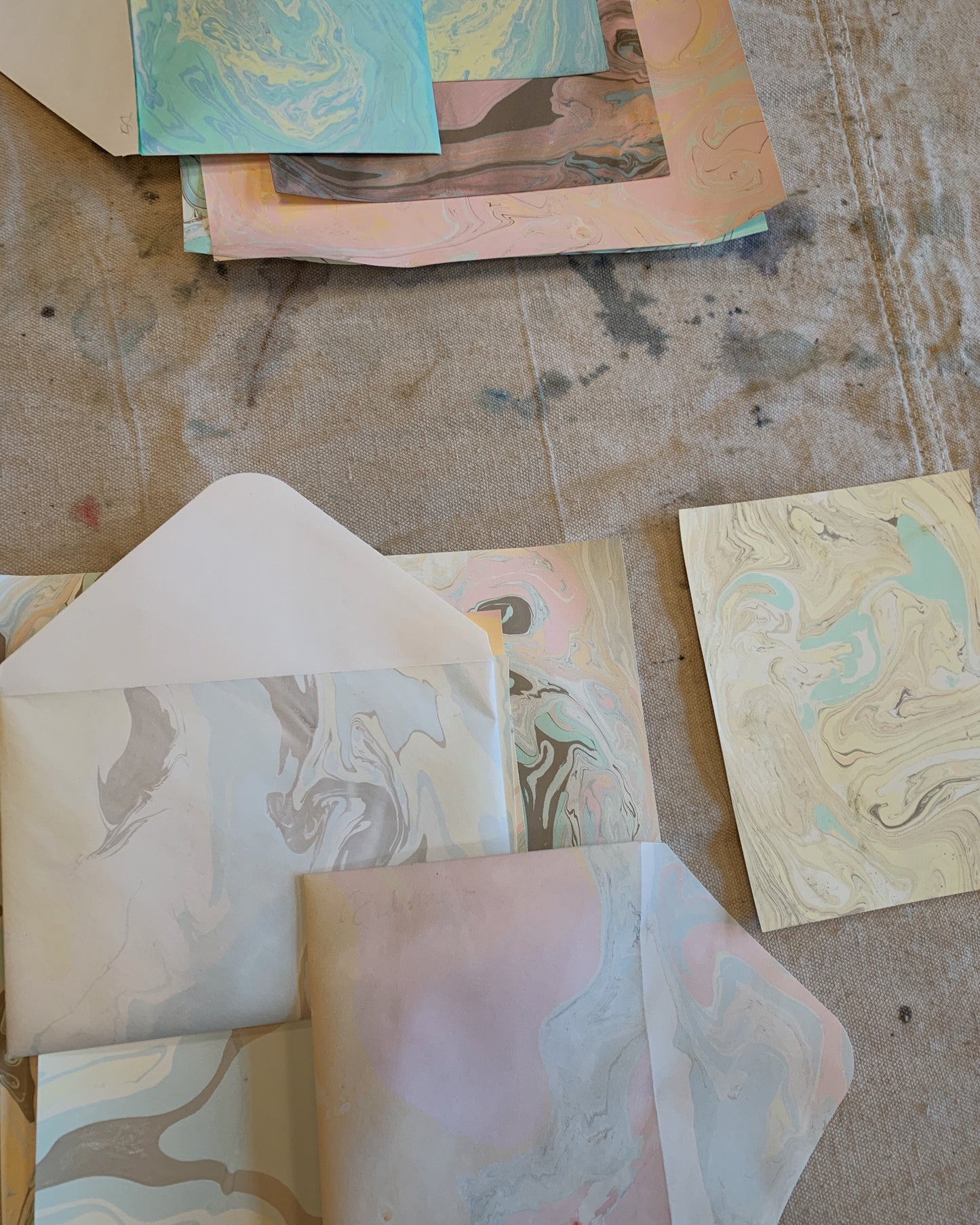 Collection of marbled paper sheets on a textured surface