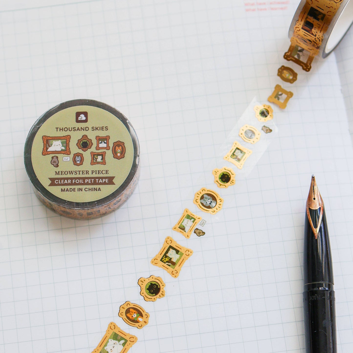 Decorative tape with gold and green designs on a notebook page with a pen.