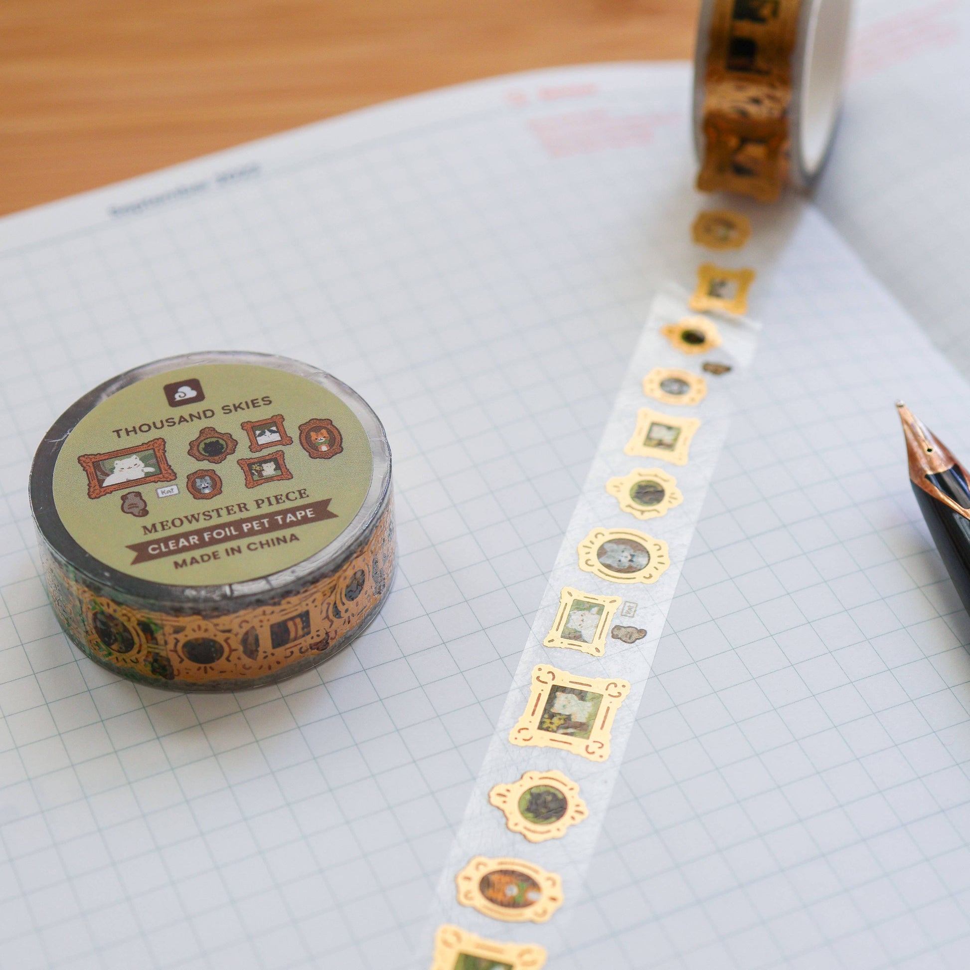 Decorative tape with gold patterns on a notebook page with a pen.