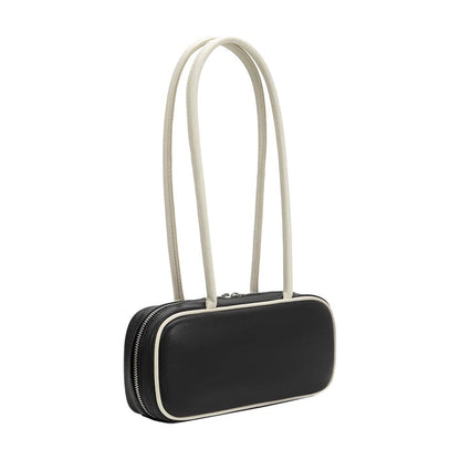 A black leather shoulder bag with a rounded rectangular silhouette, featuring a double strap in a light cream/off-white color and contrast cream piping along the edges.