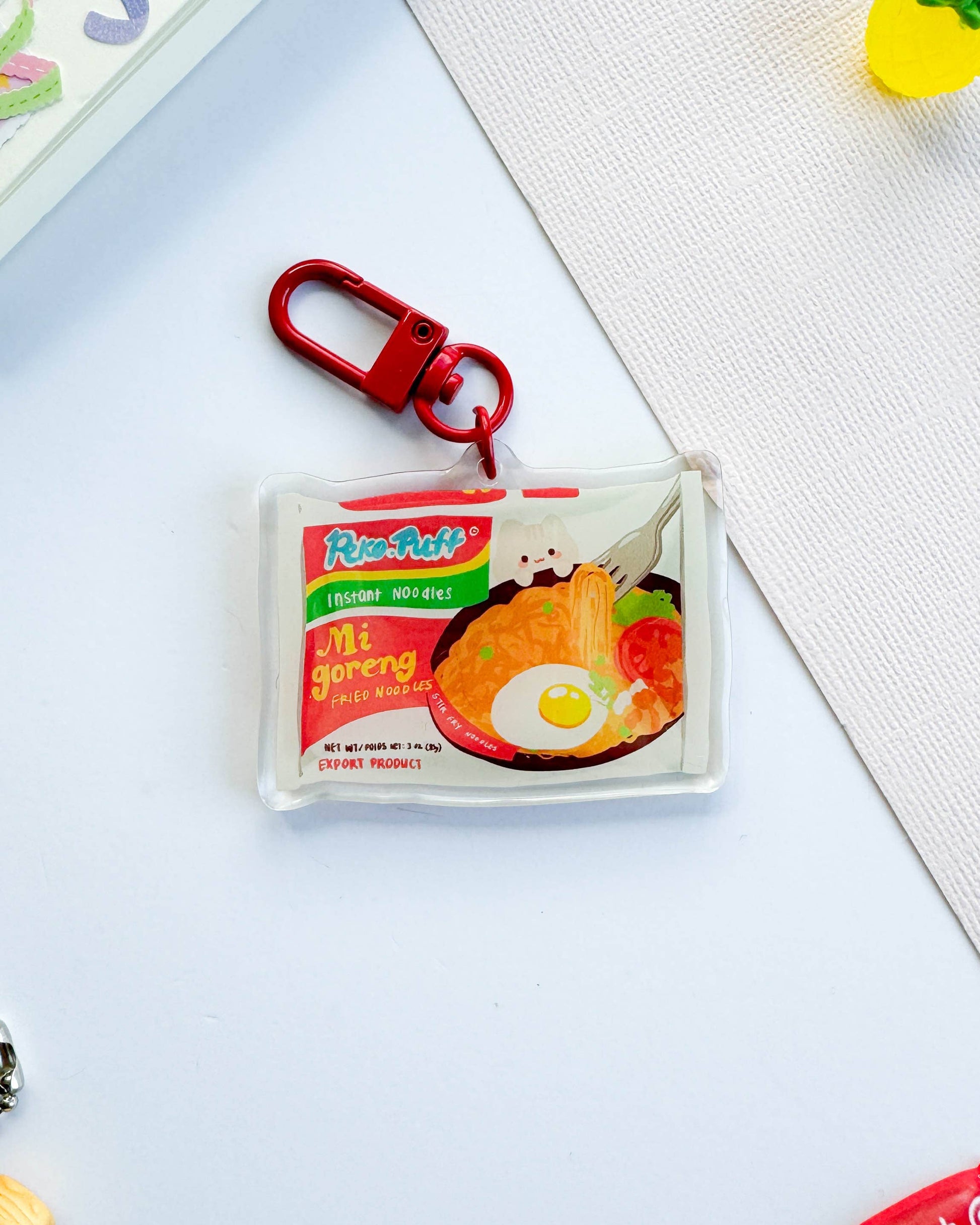 Keychain with a miniature package design on a light surface, Mie Goreng Ramen Noodles Keychain