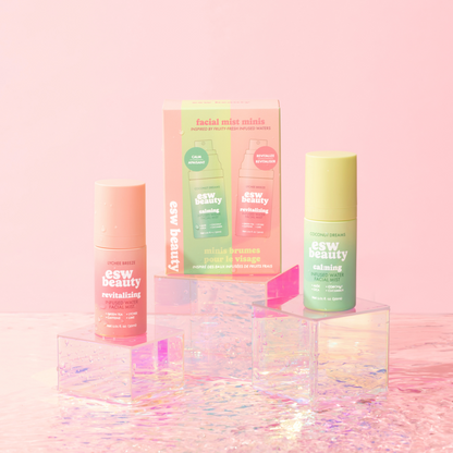 Skincare products with colorful packaging on a pink background