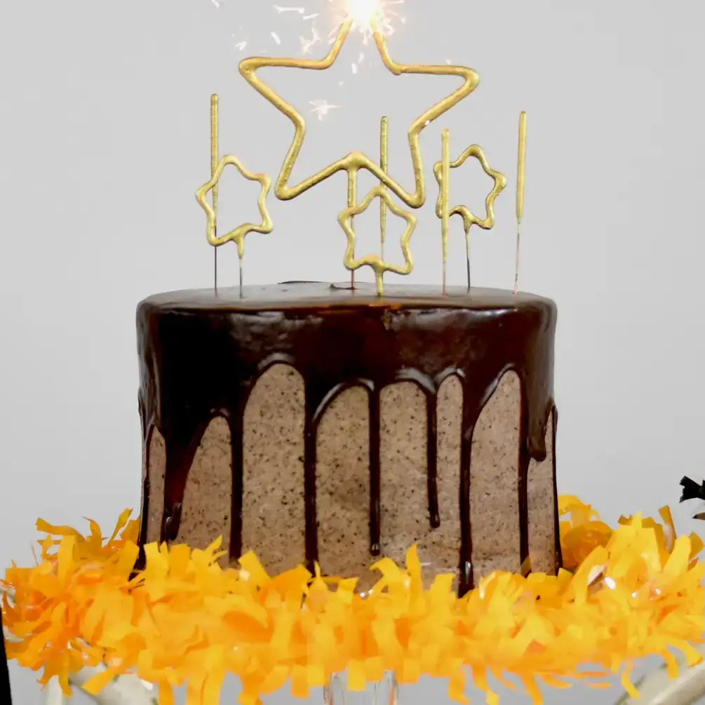 Chocolate cake with star-shaped sparklers on a white background