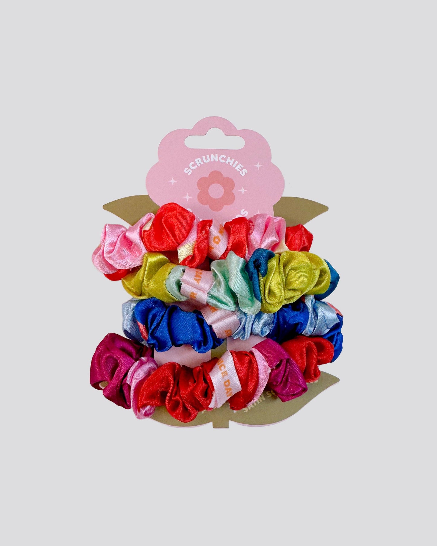 Set of colorful scrunchies on a white background with a pink packaging label.
