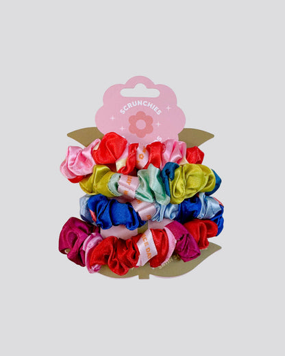 Set of colorful scrunchies on a white background with a pink packaging label.