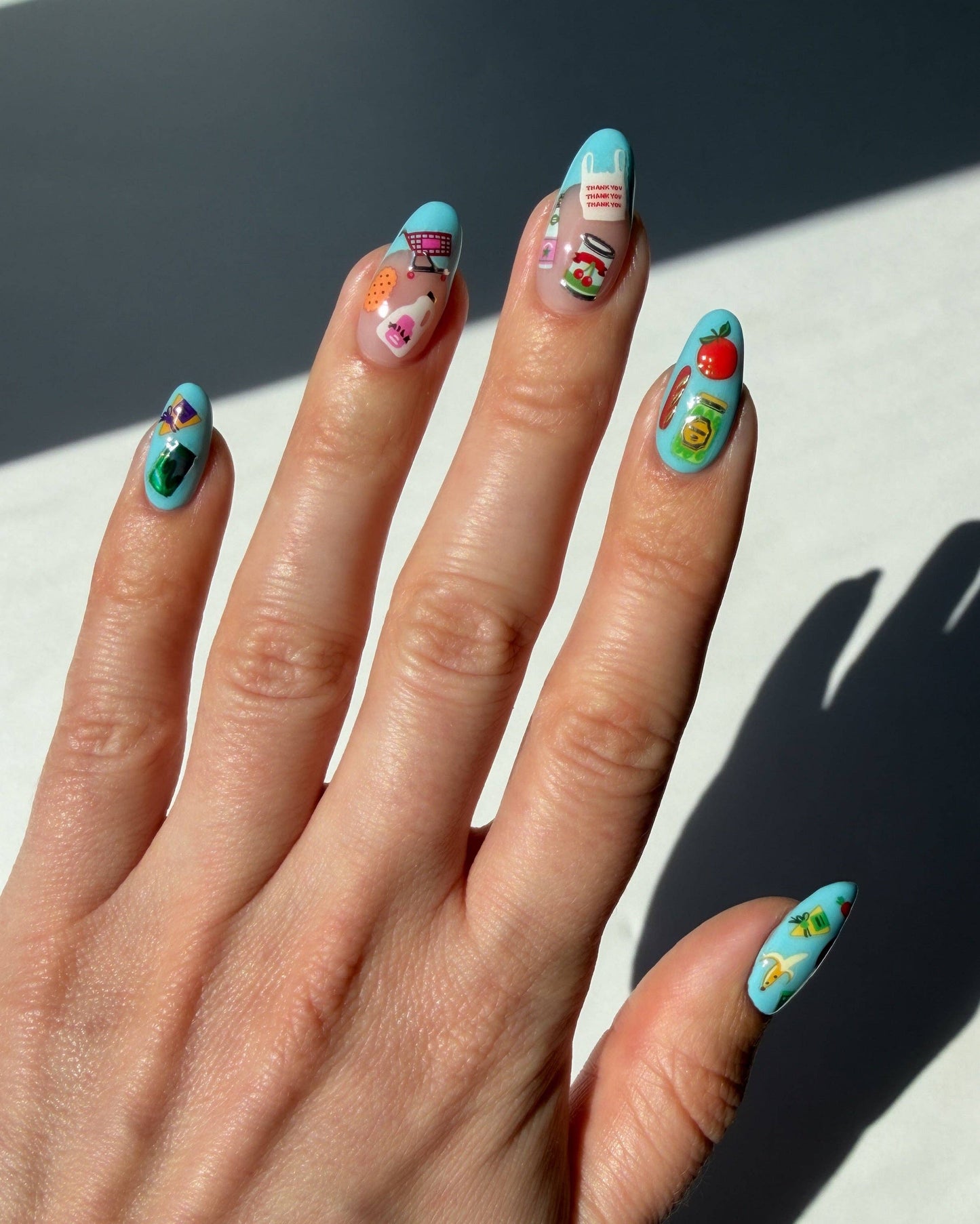Hand with colorful nail art on a light background