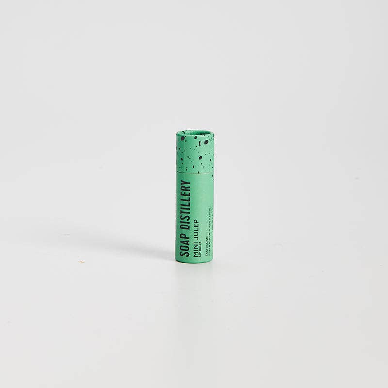 Green cylindrical container with speckled texture on a white background, Mint Julep Lip Balm